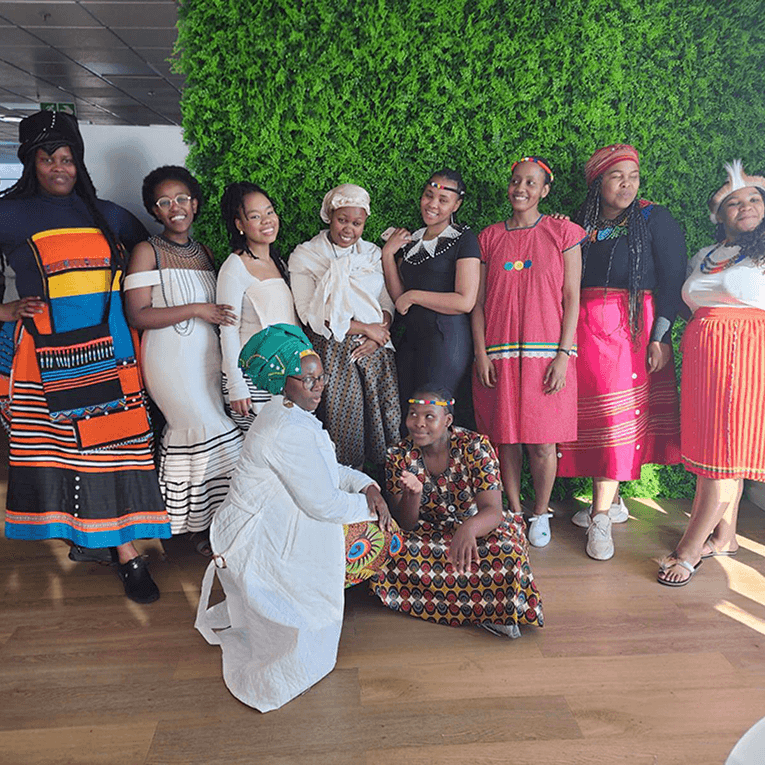 Group photo of M+C Saatchi employees in colorful outfits.